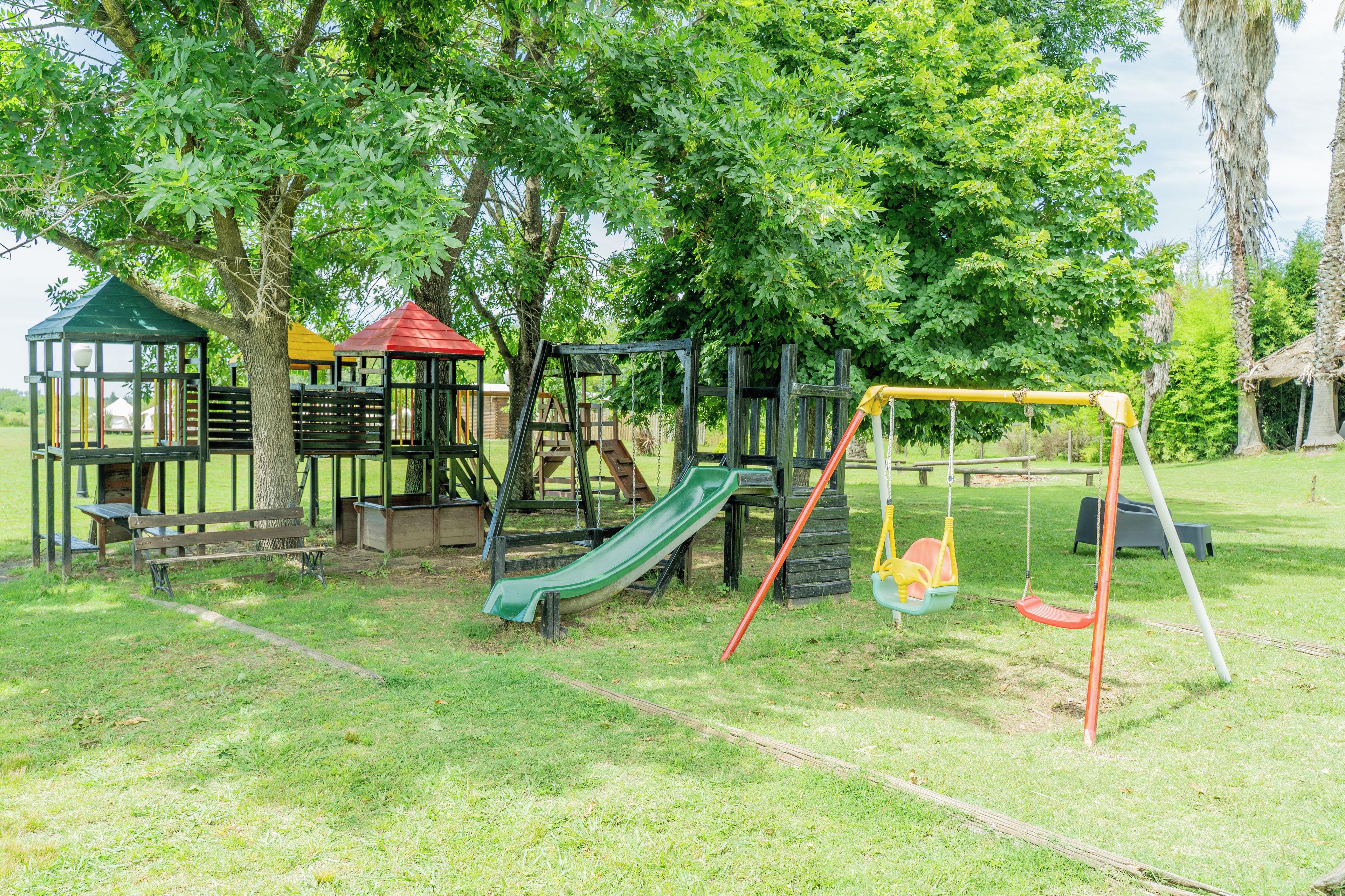 A playground with a slide, swings, and a small shelter.