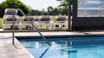 Una piscina techada, sillones reclinables de piscina