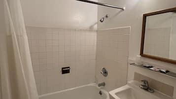 A modern bathroom with a bathtub, a sink, and a shower.