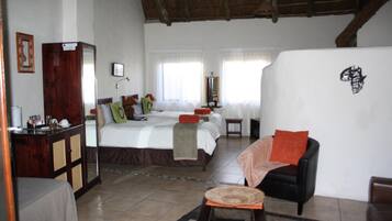 A hotel room with a bed, a desk, a chair, and a small table.