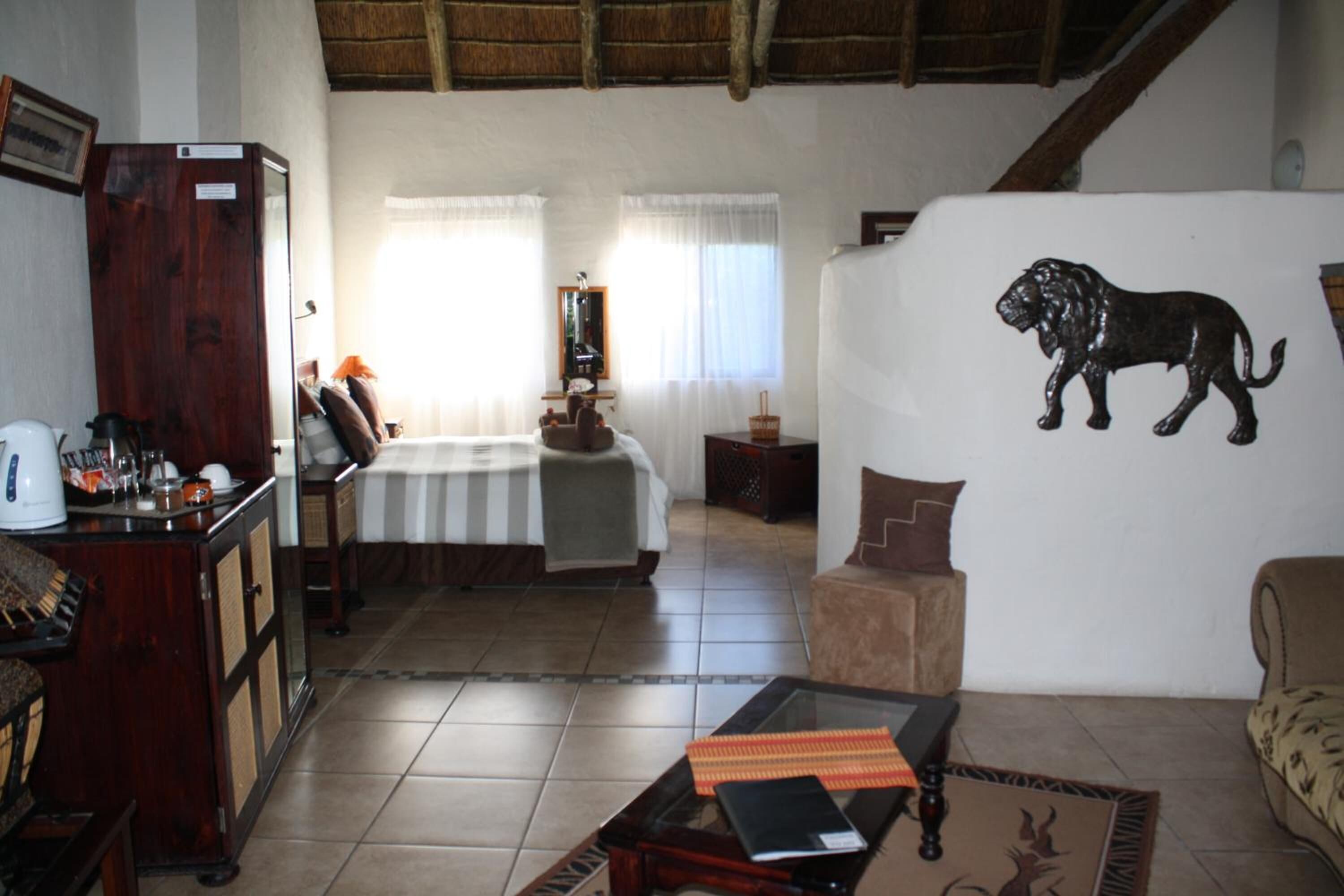 A cozy living room with a bed, a coffee table, and a wall-mounted animal decoration.