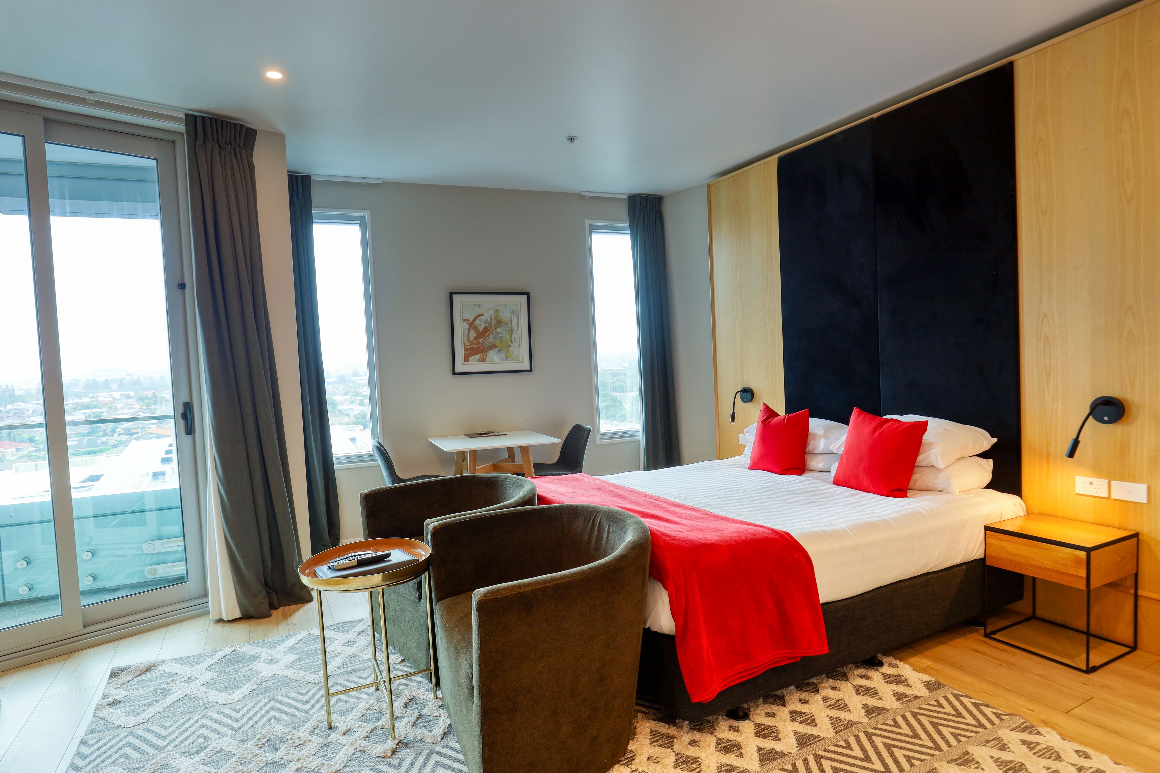 Une chambre d’hôtel moderne avec un grand lit, un bureau et une vue sur la ville.