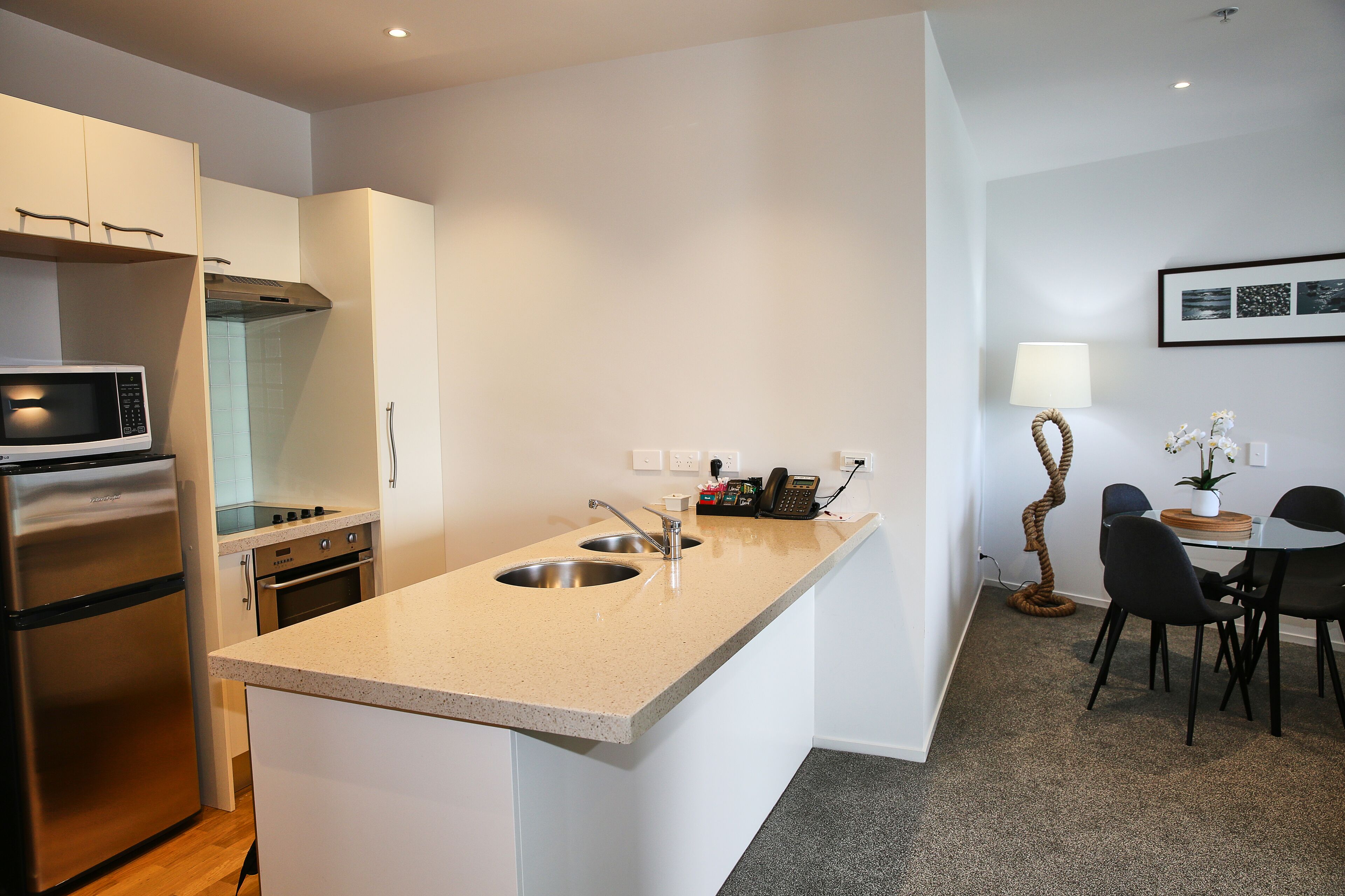 A modern kitchen with a built-in microwave, stainless steel refrigerator, and double sink.