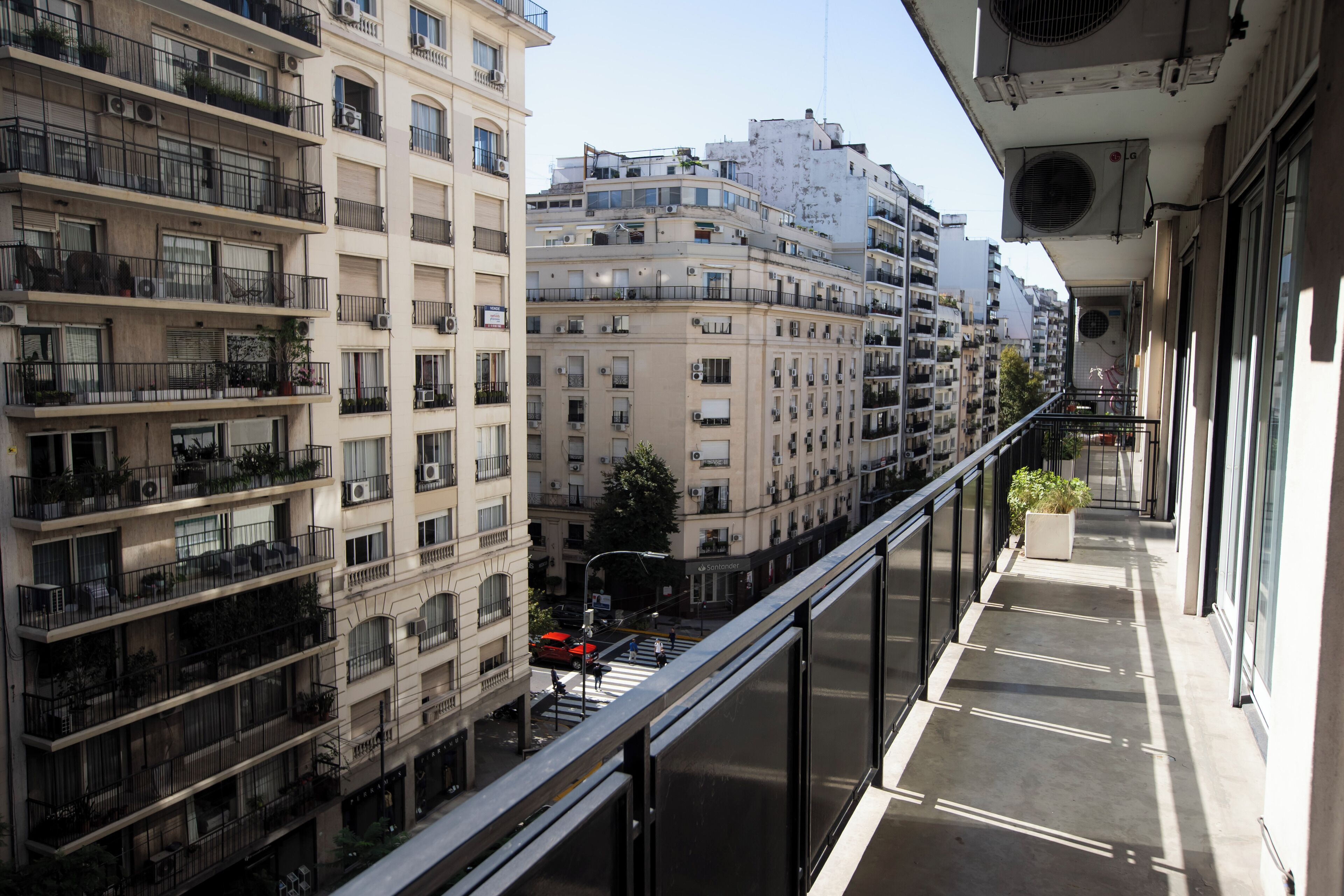A high-rise building with multiple balconies, large windows, and air conditioning units.