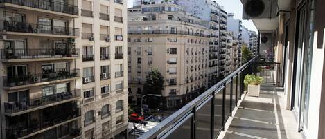 A high-rise building with multiple balconies, large windows, and air conditioning units.