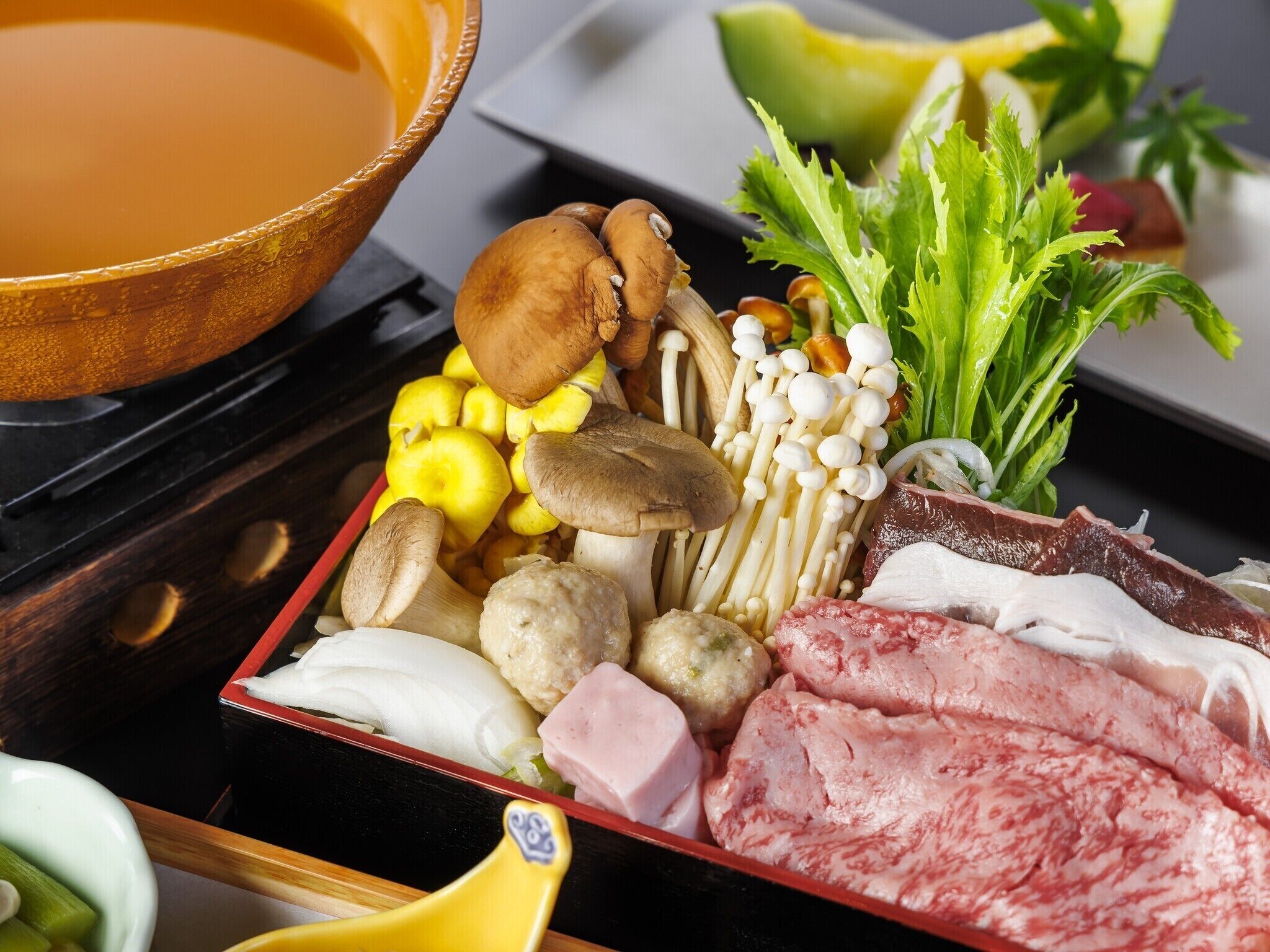 Une variété d’aliments, notamment des champignons, de la viande et des légumes, disposés sur un plateau.