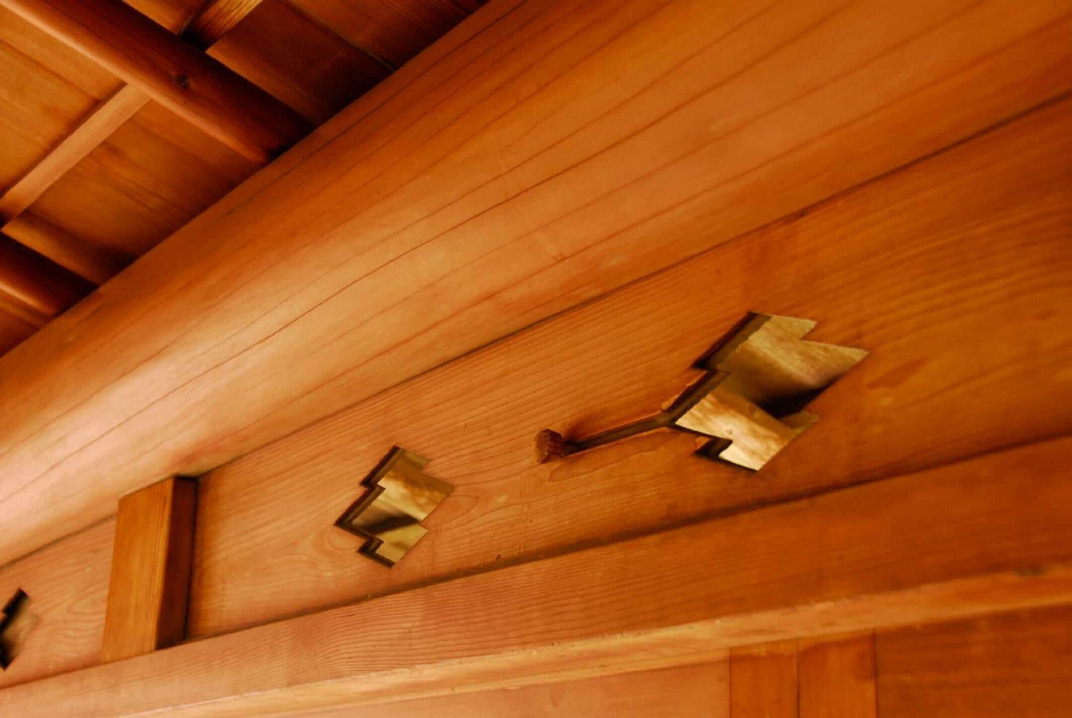 A wooden ceiling with exposed beams and metal brackets.