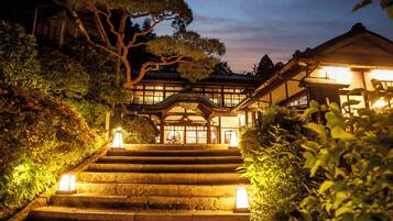 A traditional Japanese building with a staircase leading to a wooden entrance.