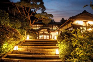 Un edificio japonés tradicional con una escalera que conduce a una entrada de madera.