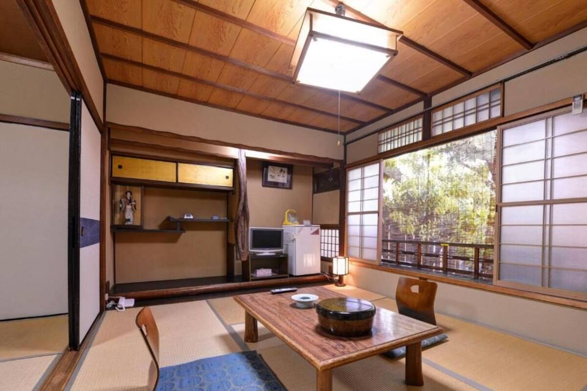 A traditional Japanese room with tatami flooring, a low table, and shoji screens.