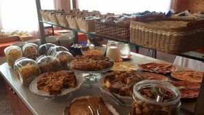 Un bufé con diversos productos horneados, entre ellos tartas y pasteles, y frascos con salsas y aderezos.