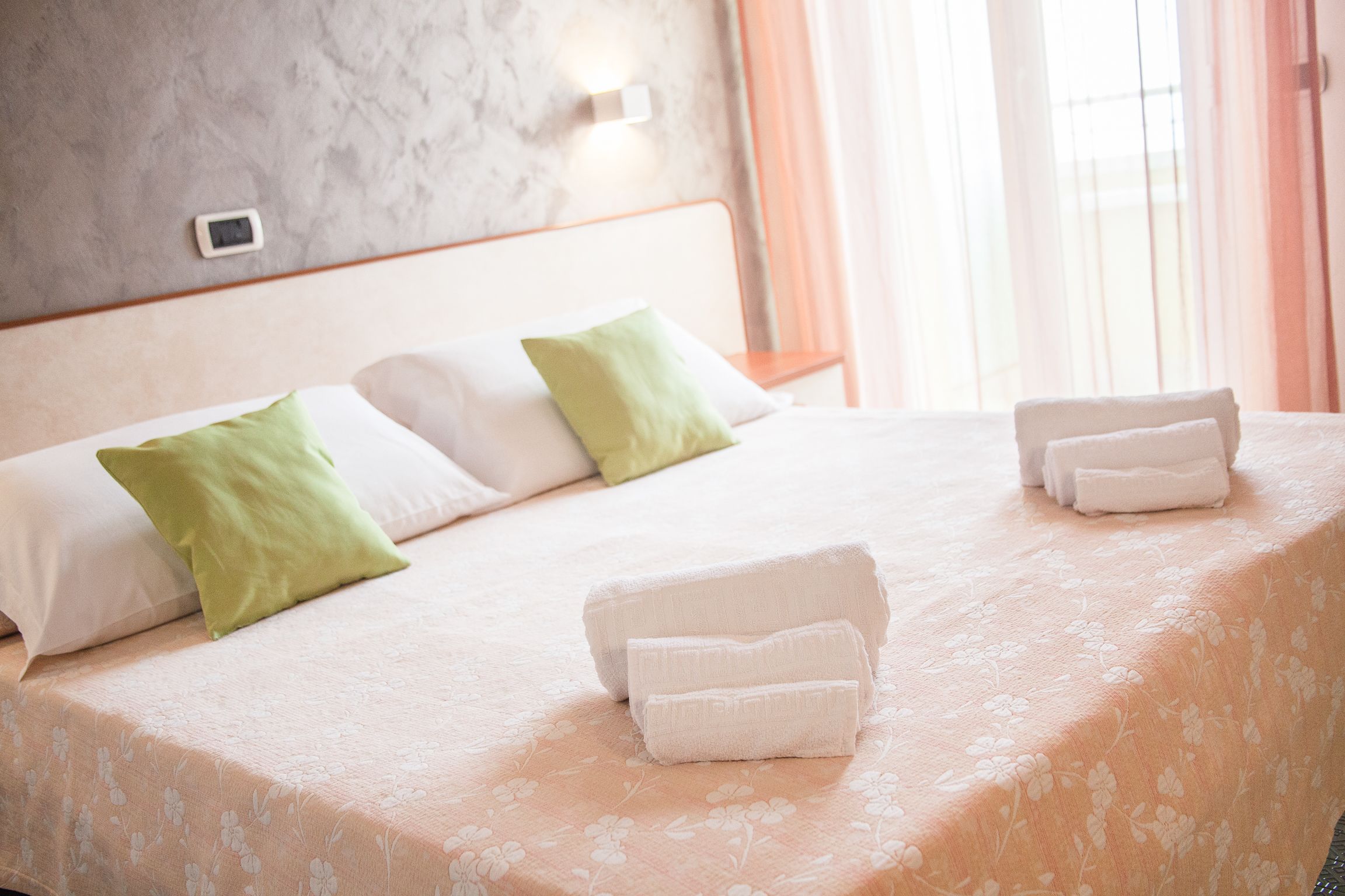 Ein Hotelzimmer mit Bett, Kissen und Handtüchern.