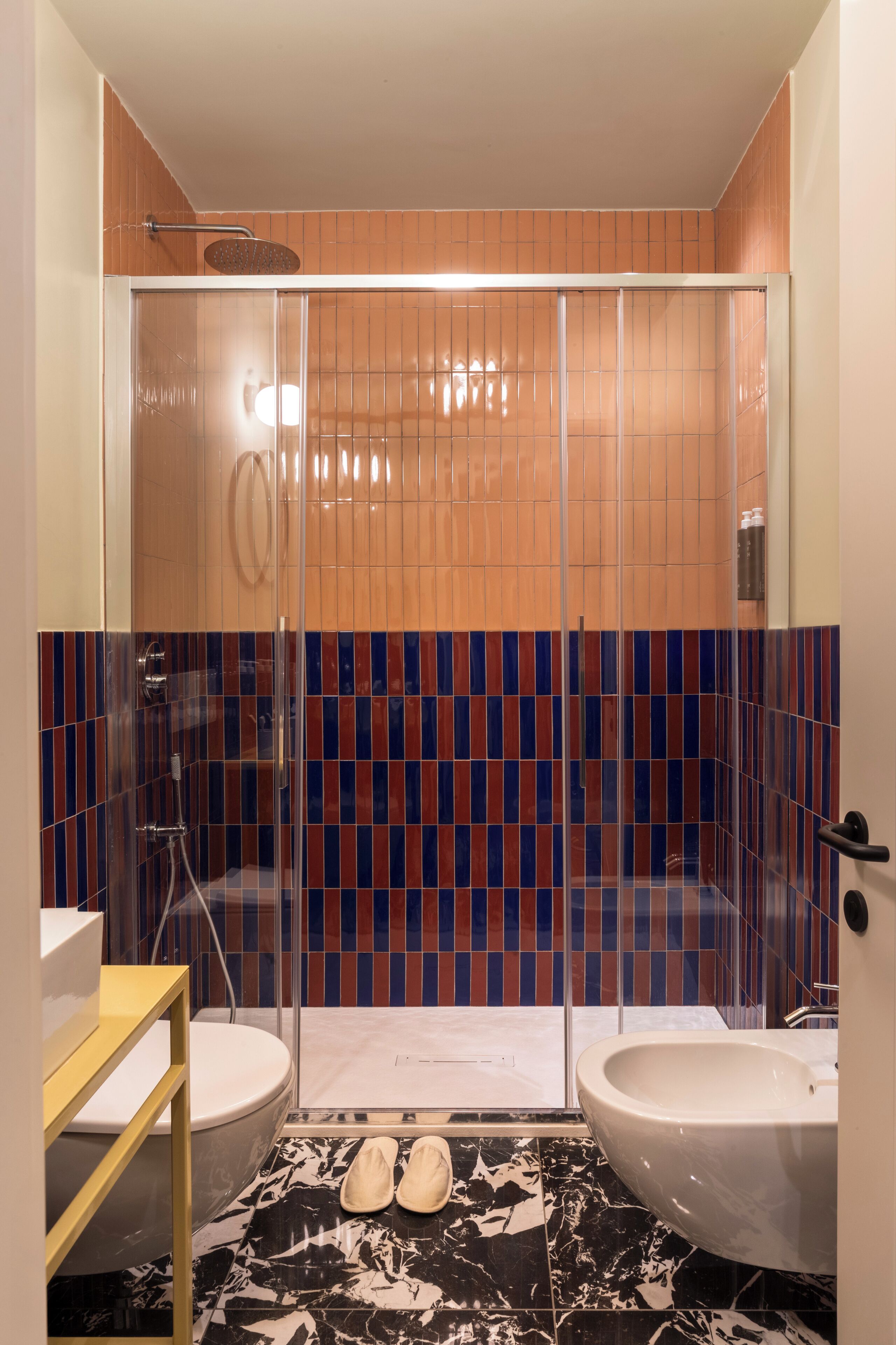 Un baño con ducha envuelta en vidrio, inodoro, lavamanos y bidé.