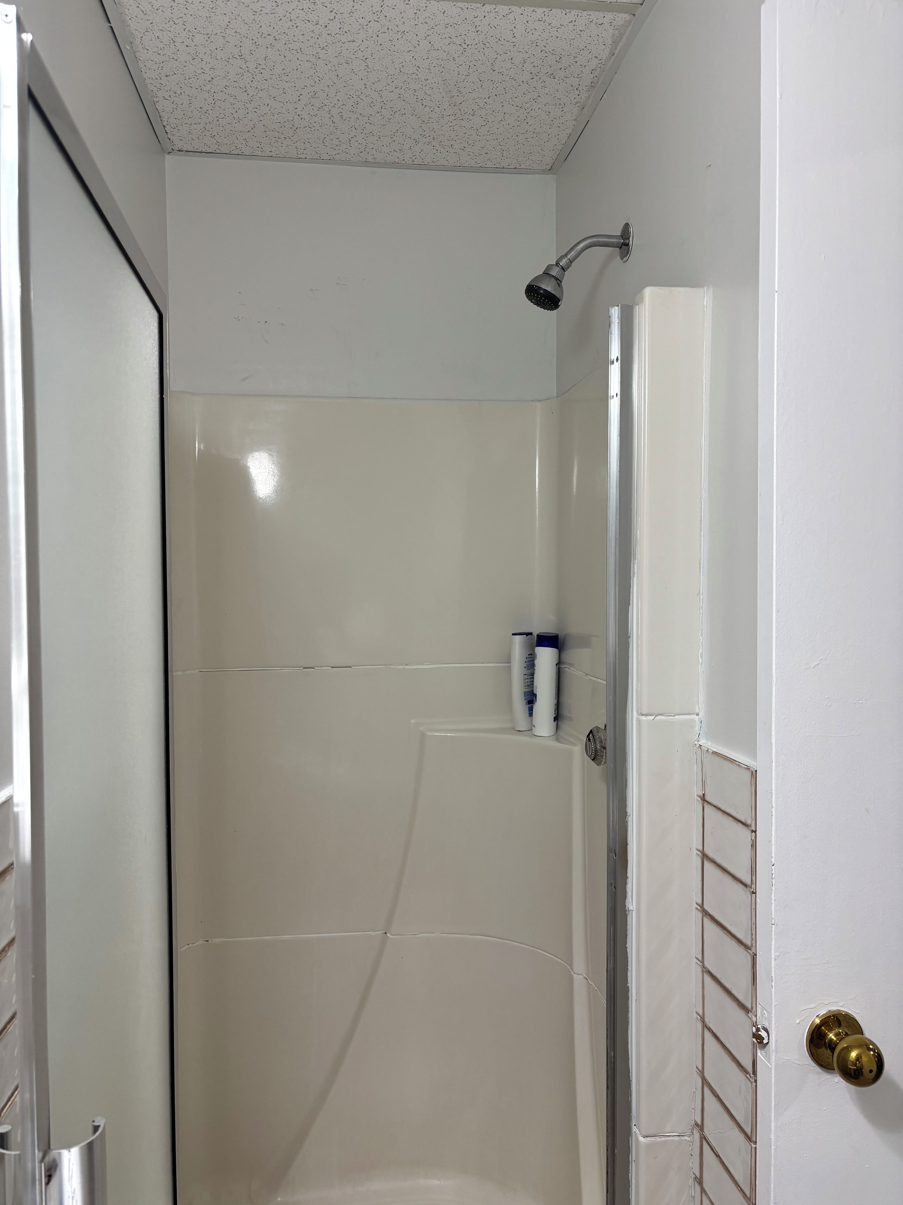 A bathroom with a shower, a toilet, and a sink.