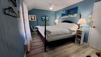 Quarto com cama de dossel, escrivaninha e uma cadeira.