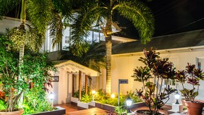 A well-lit reception area with a sign indicating "RECEPTION" and a building with a sign that reads "French Verandah Restaurant" in the background. - Mariners Hotel (Villa)
