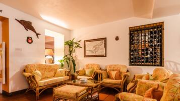 A living room with wicker furniture, a map, and a wine rack.