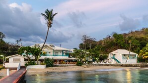 A beachfront property with a pool, a covered patio, and a view of the ocean. - Mariners Hotel (Villa)