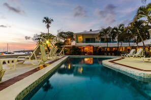 Una piscina al aire libre, sillones reclinables de piscina