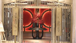 A hotel entrance with a decorative gate, a table with vases, and Chinese characters on the gate. -  Hangzhou Xingdu Hotel (Hangzhou)