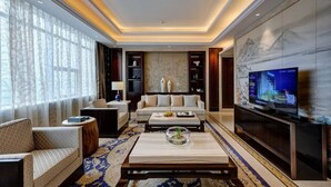 A modern living room with a sofa, coffee table, and television. -  Hangzhou Xingdu Hotel (Hangzhou)