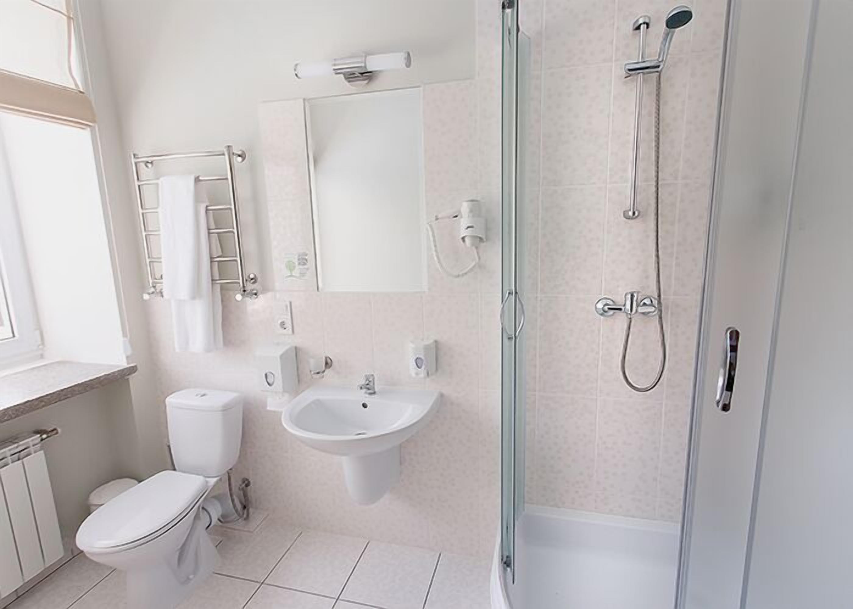 A modern bathroom with a toilet, sink, and shower.
