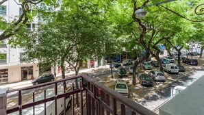 A street view with parked cars, trees, and buildings. - Hotel Capital (Lisbon)