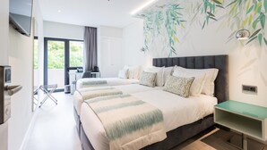 A modern hotel room with two beds, a desk, and a large window. - Hotel Capital (Lisbon)