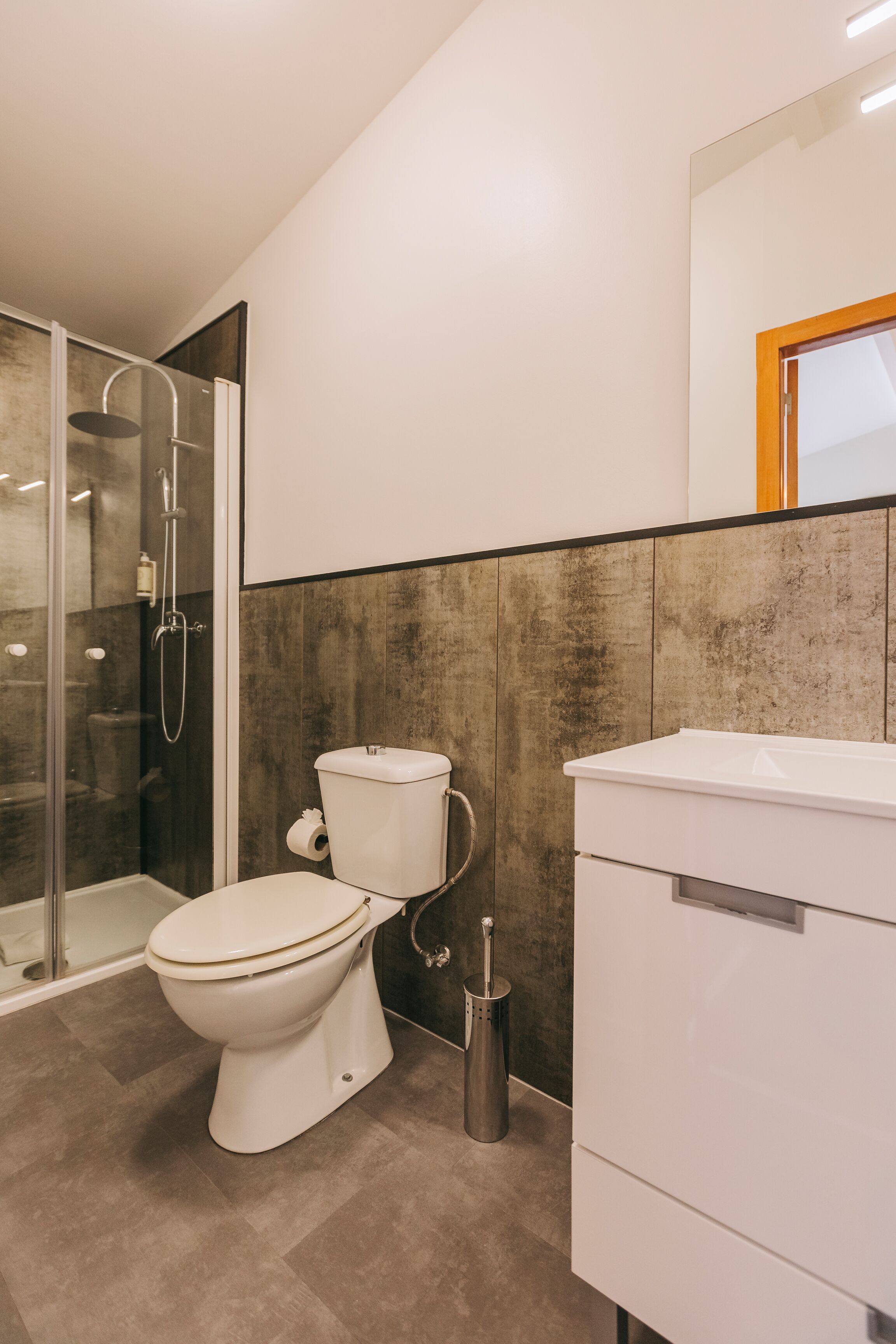 Ein modernes Badezimmer mit Toilette, Dusche und Waschbecken.