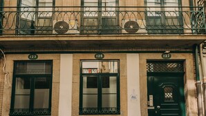 A multi-story building with numbered windows and a green door. - Oporto Maison Sol   (Porto)