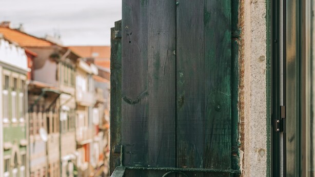 A wooden gate with a metal latch, part of a building's exterior. - Oporto Maison Sol   (Porto)
