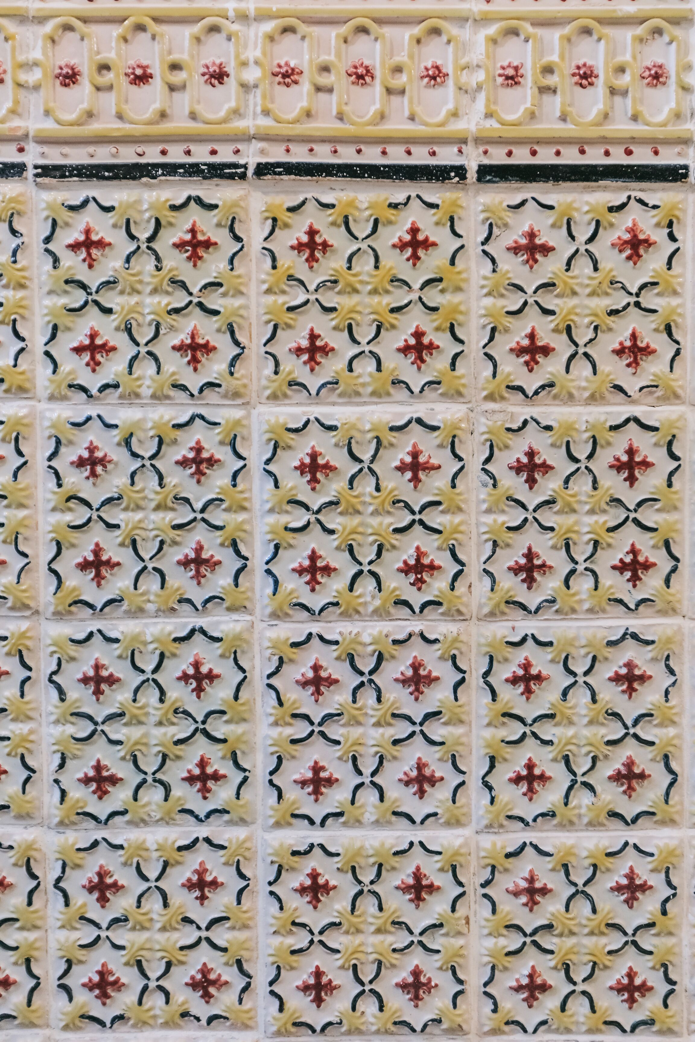 A tiled wall with a repeating geometric pattern.