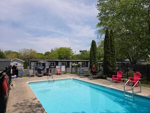 Une piscine avec des chaises longues et un cercle de sauvetage.