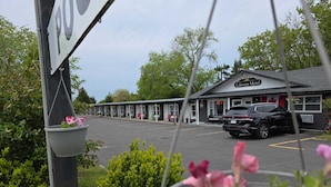A motel with a row of cabins, a parking lot, and a black SUV parked in front. - Lakeview Motel (Kincardine)