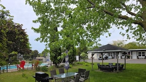 A patio area with outdoor furniture, a barbecue grill, and a covered seating area. - Lakeview Motel (Kincardine)