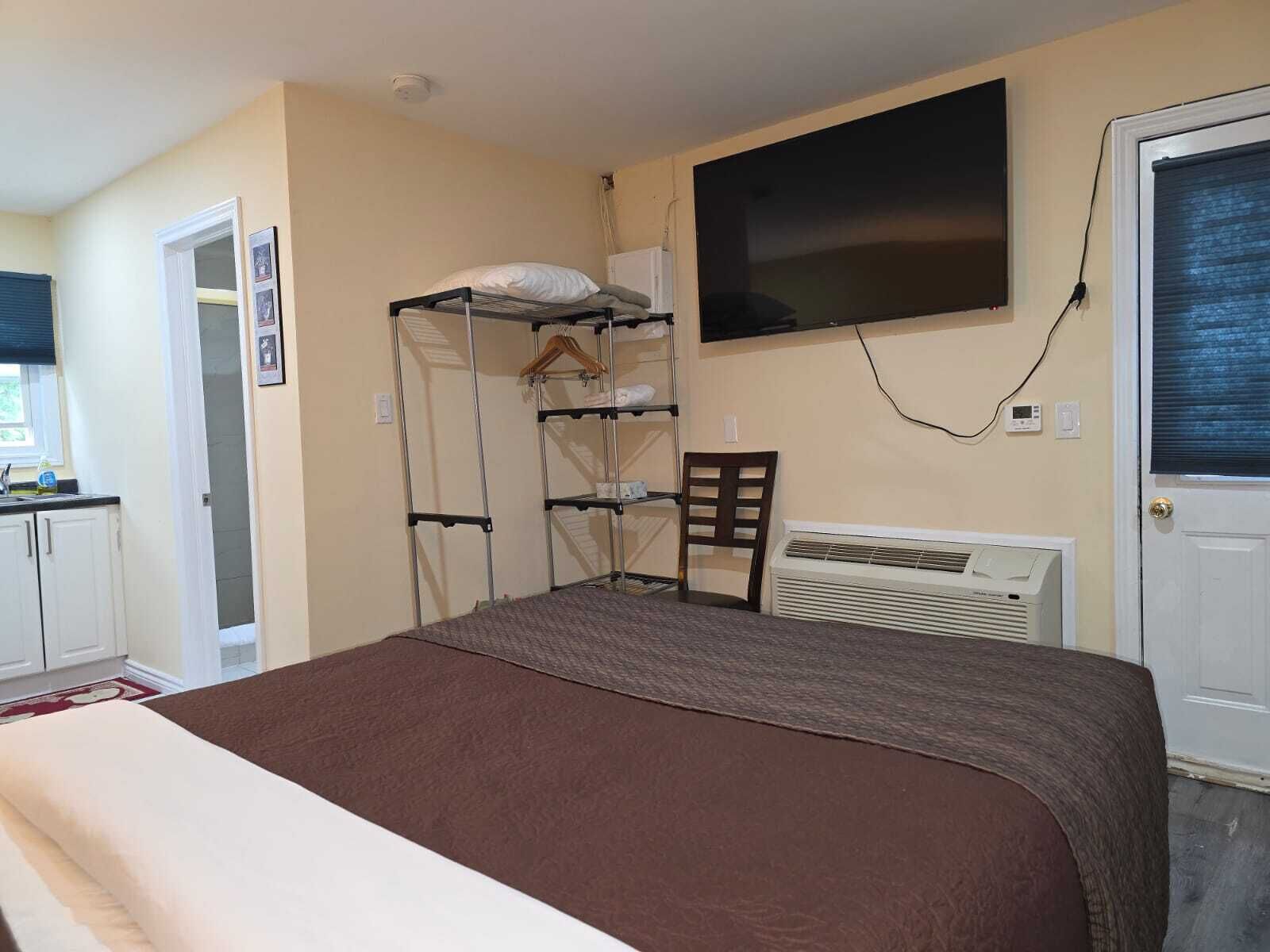 A bedroom with bunk beds, a desk, a chair, a radiator, and a TV.