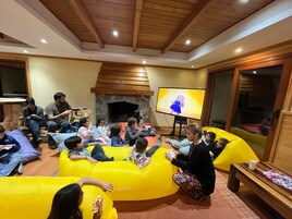 Una habitación acogedora con chimenea de piedra, vigas de madera y un televisor de pantalla plana grande.