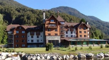 Un hotel de varios pisos con estilo arquitectónico tradicional, que cuenta con balcones y un patio central.