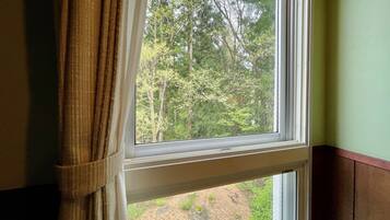 A window with a view of a forested area outside.