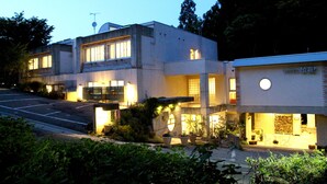 Un hotel moderno con struttura su due piani, ampie finestre e un ingresso ben illuminato.