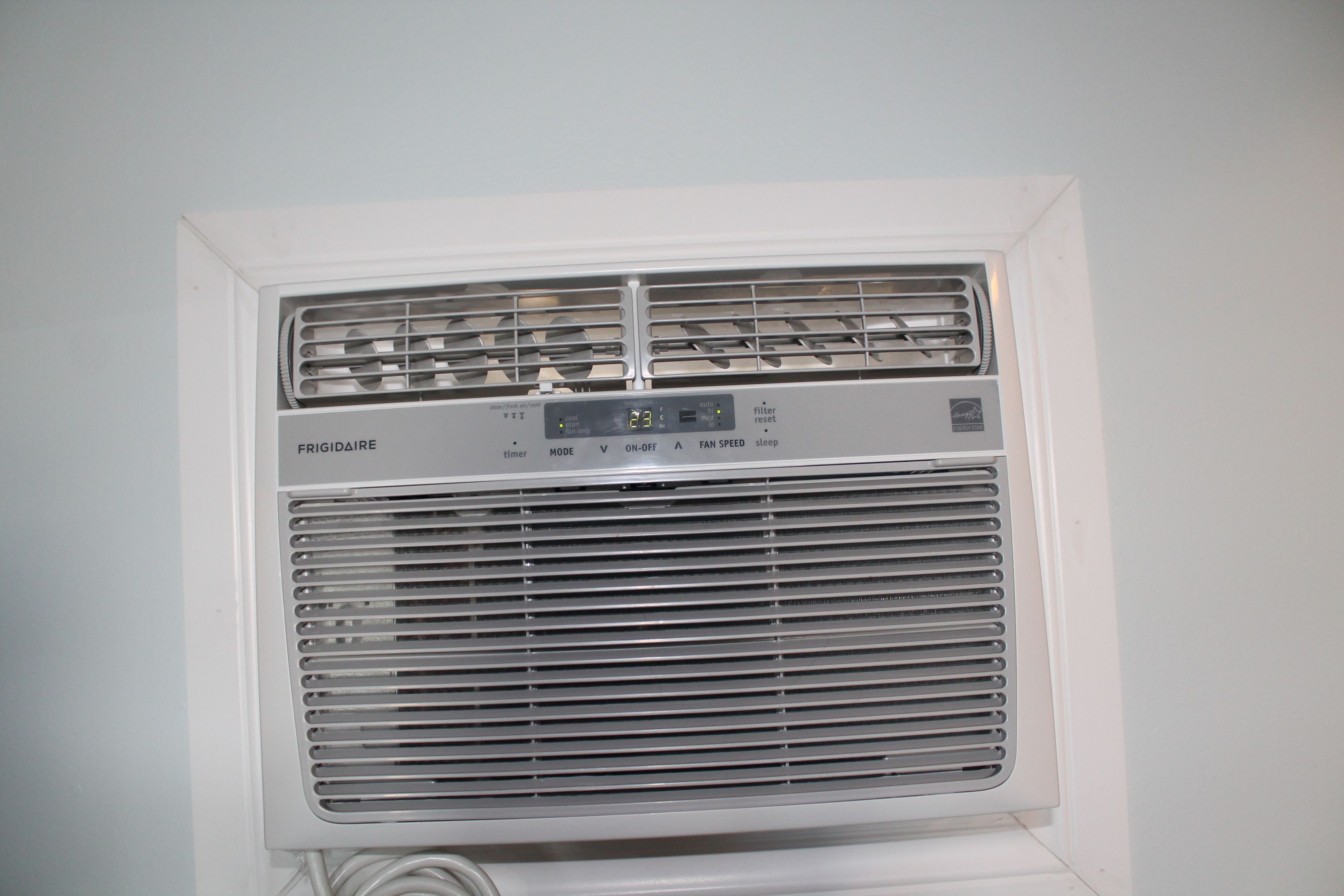Un aire acondicionado portátil blanco con pantalla digital, botones de control y rejilla de ventilación.