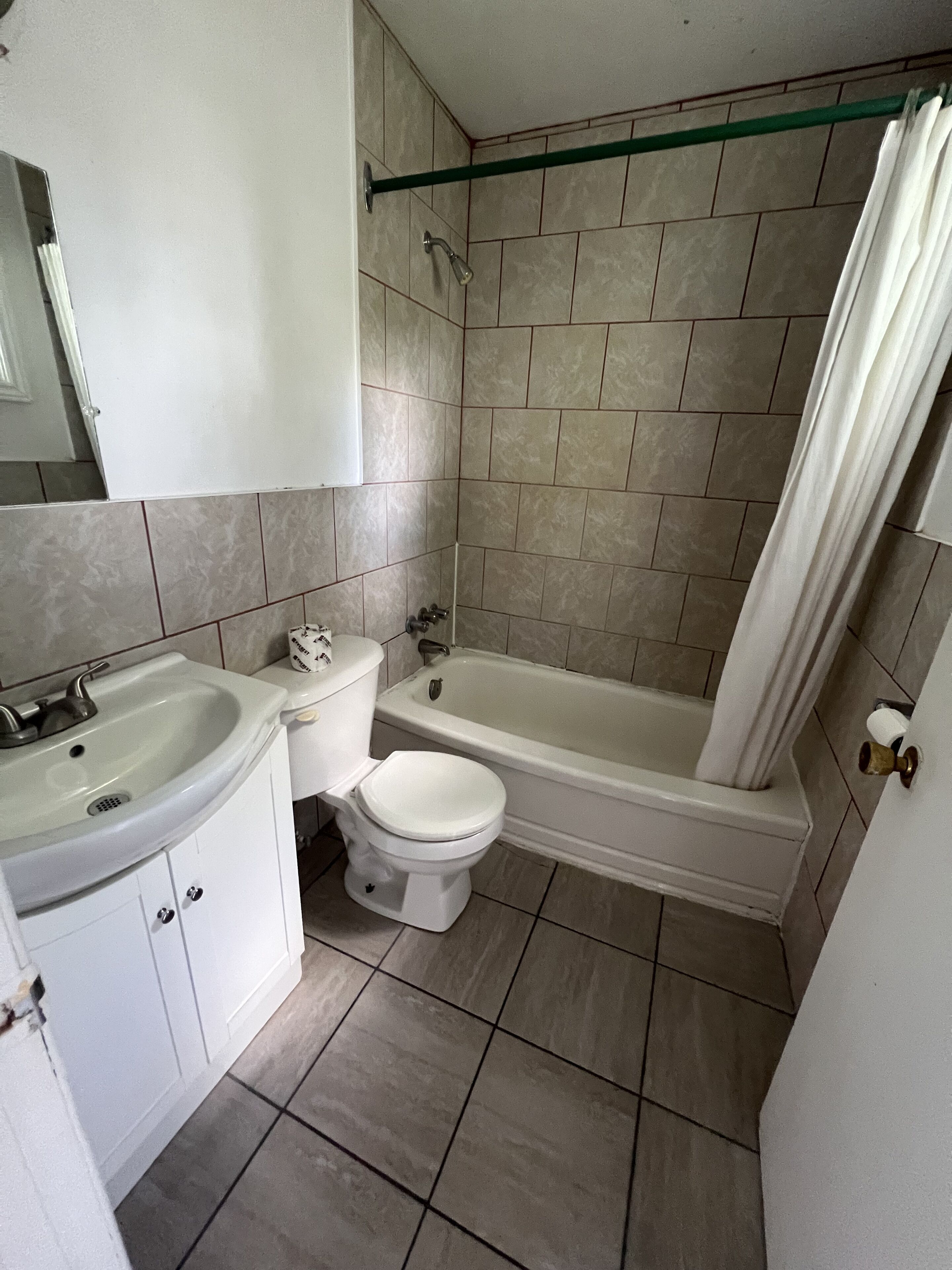 A bathroom with a toilet, sink, and bathtub.