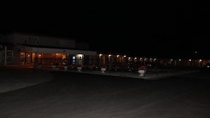 A building with a large parking lot and a few illuminated windows. - Elect Inn 5 (Cornwall)