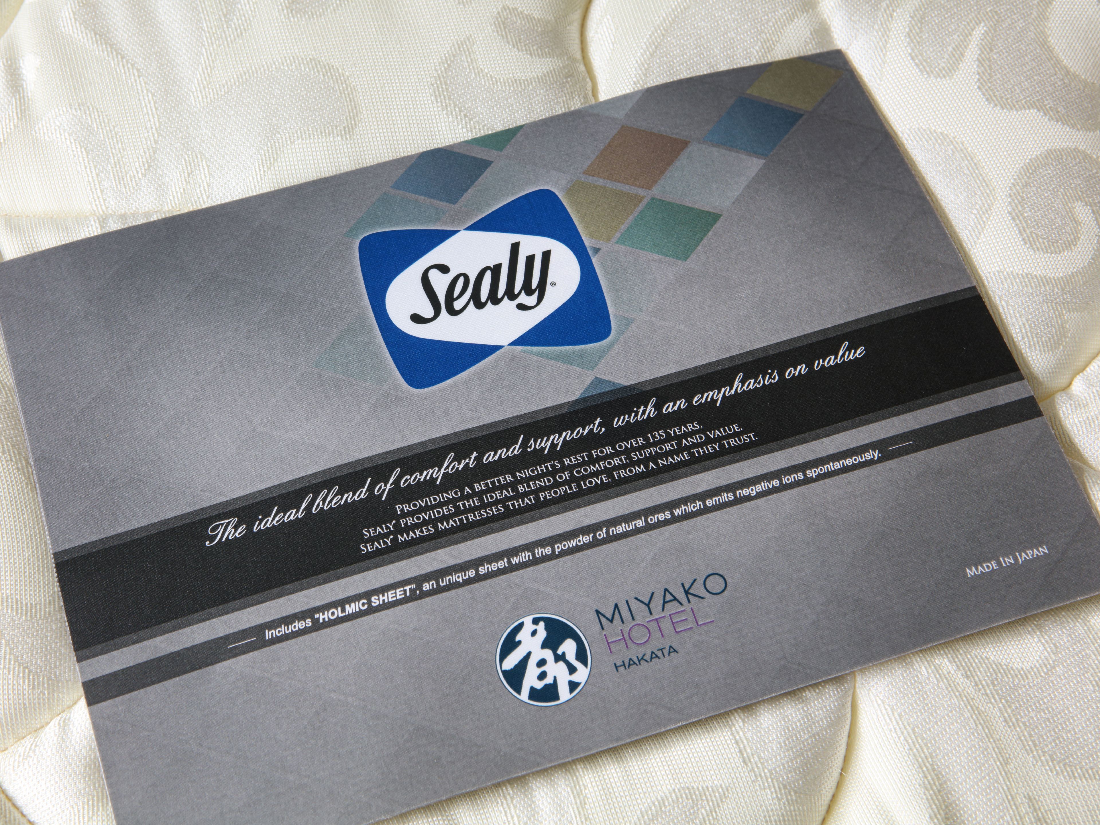 A Sealy mattress advertisement on a fabric background.