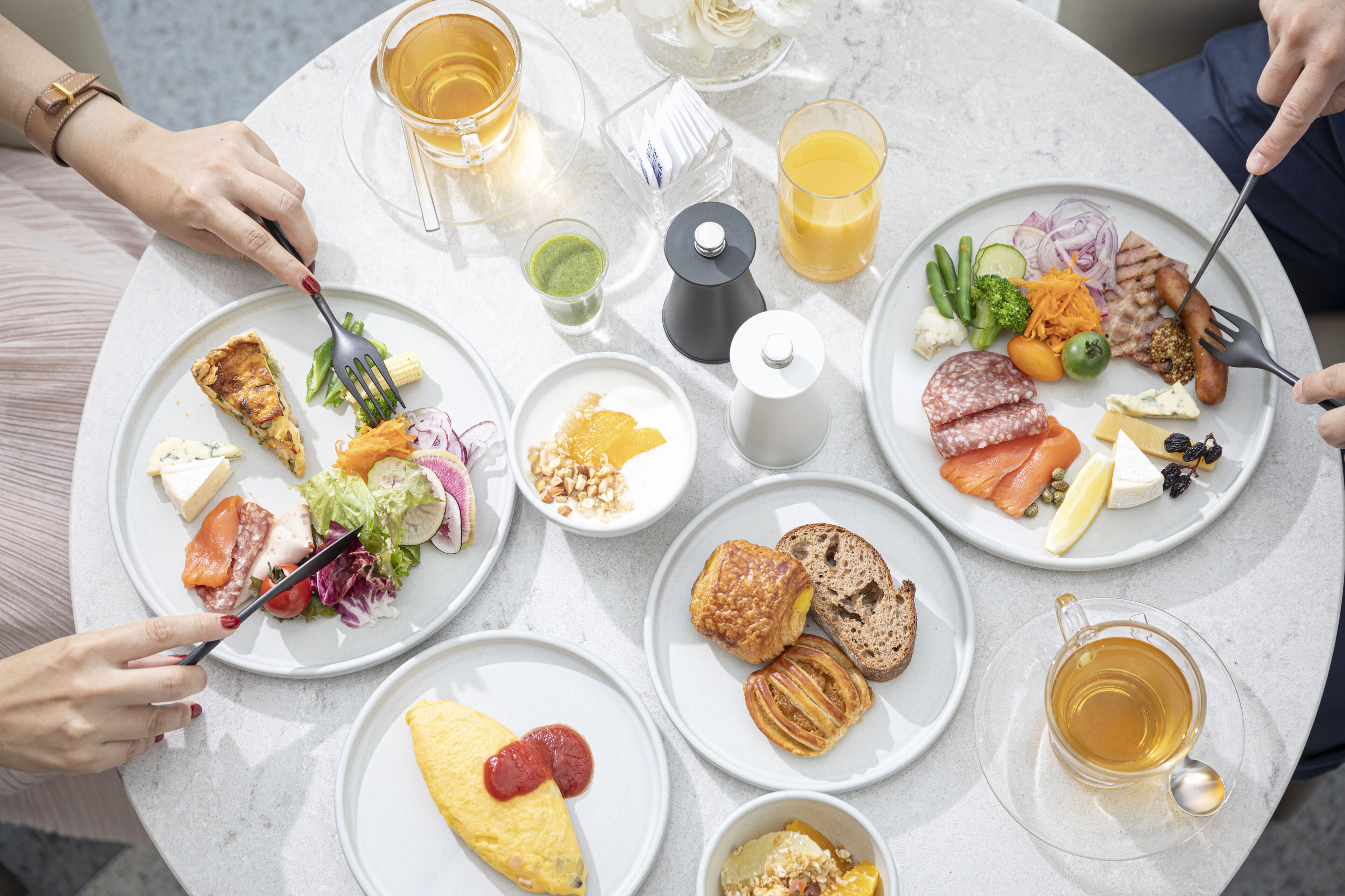 Ett runt bord med ett urval av frukosträtter, inklusive ägg, bakverk och frukt.