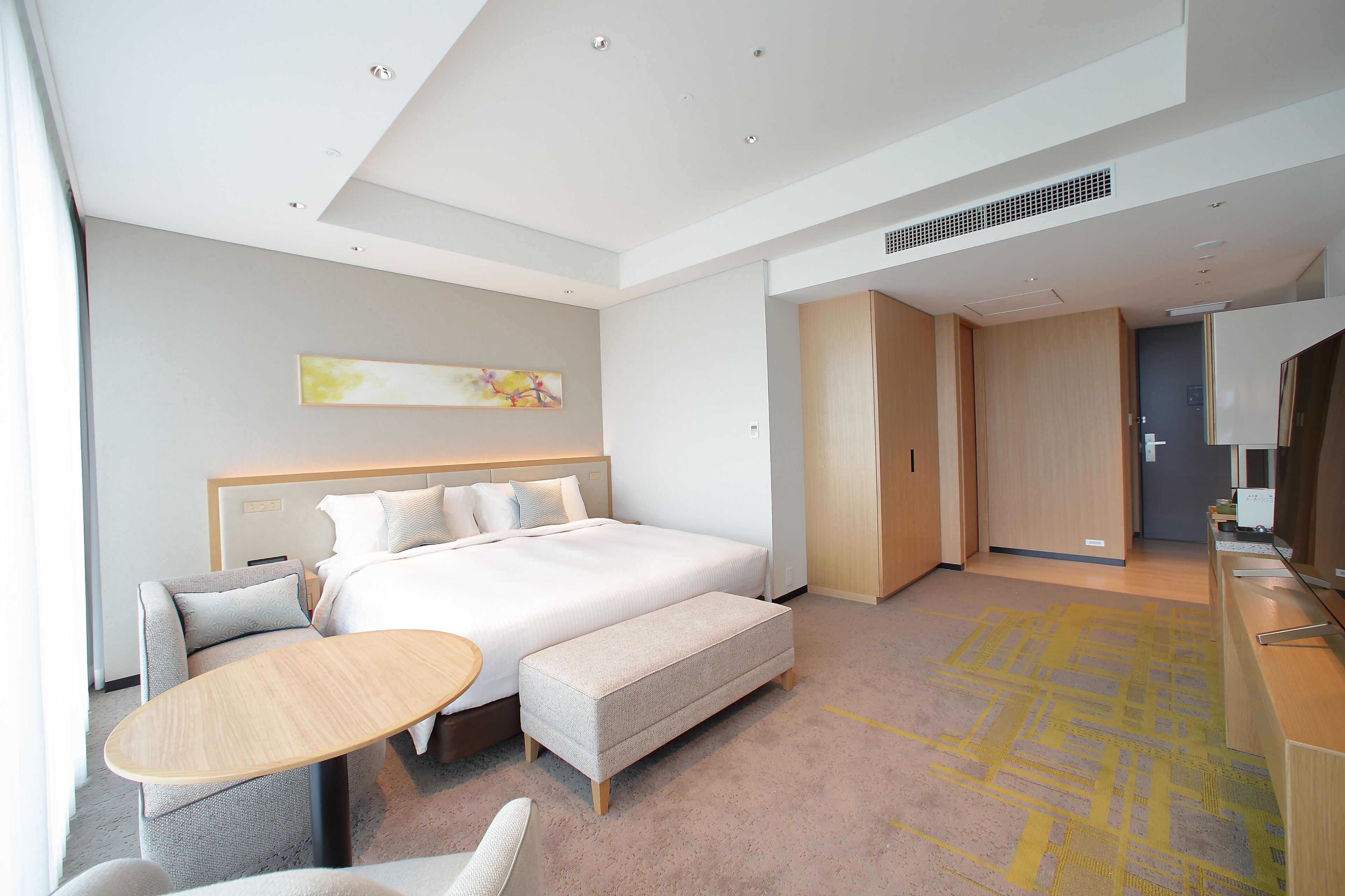 Een moderne hotelkamer met een groot bed, een zithoek en een bureau.