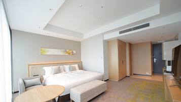 Een moderne hotelkamer met een groot bed, een zithoek en een bureau.