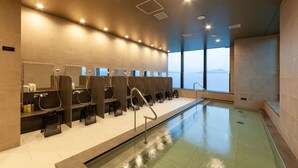 Een moderne badkamer met meerdere douchecabines, een grote spiegel en een zwembad.
