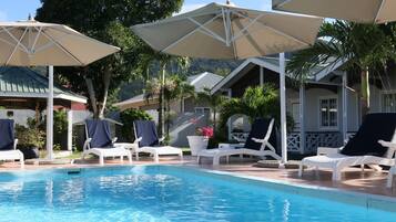 Een buitenzwembad, parasols voor strand/zwembad