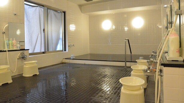 A bathroom with a large bathtub, multiple sinks, and a window. - Hotel Maruchu Classico (Tokyo)